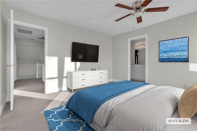 bedroom featuring ceiling fan, light colored carpet, and ensuite bath