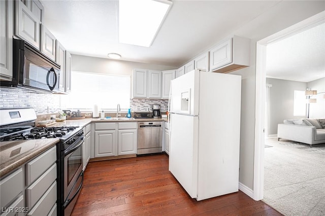 kitchen with backsplash, dark hardwood / wood-style floors, sink, and stainless steel appliances