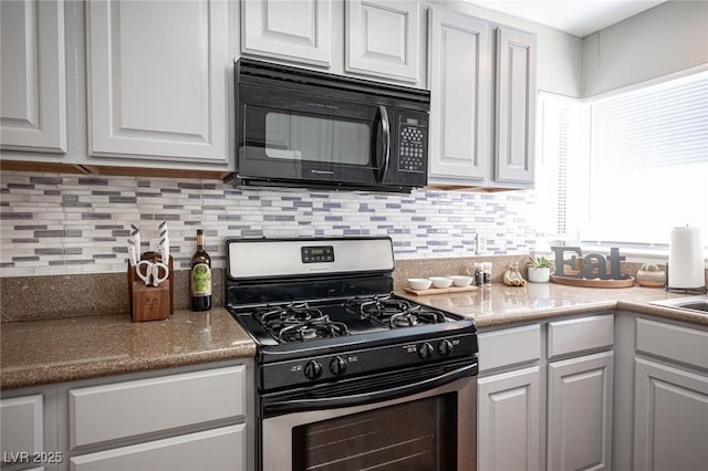 kitchen with white cabinets, stainless steel range with gas cooktop, and backsplash