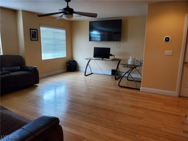 living room with ceiling fan and light wood-type flooring