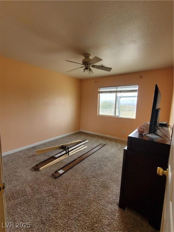 unfurnished bedroom featuring ceiling fan, carpet floors, and a textured ceiling