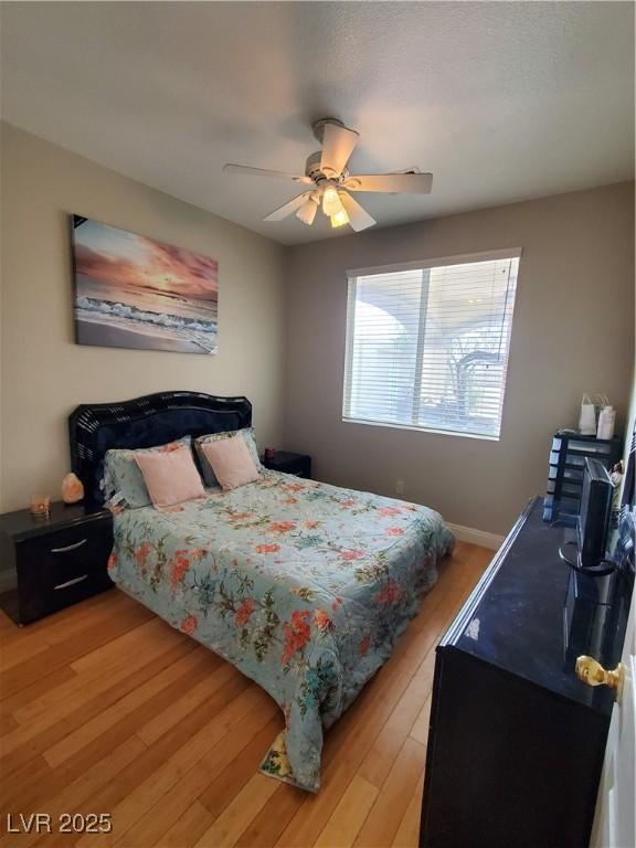 bedroom with ceiling fan and light hardwood / wood-style floors