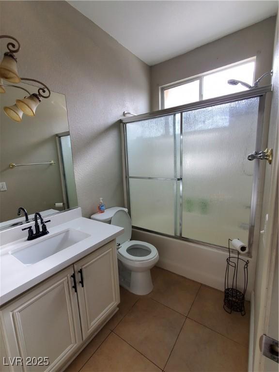 full bathroom with enclosed tub / shower combo, vanity, tile patterned floors, and toilet