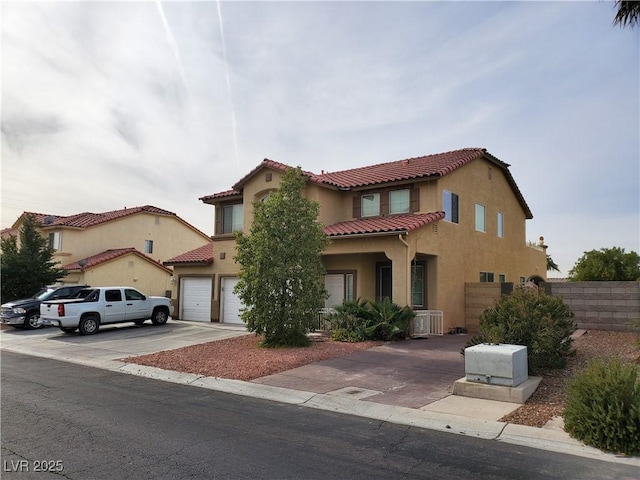 mediterranean / spanish home featuring a garage and central AC unit