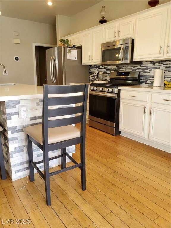 kitchen with stainless steel appliances, white cabinetry, sink, and tasteful backsplash