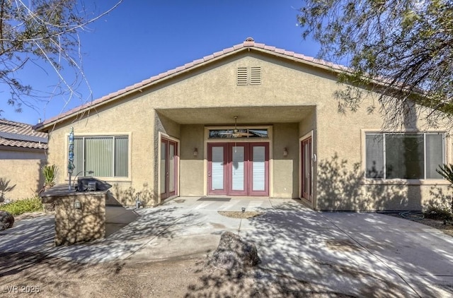 rear view of house with french doors and a patio