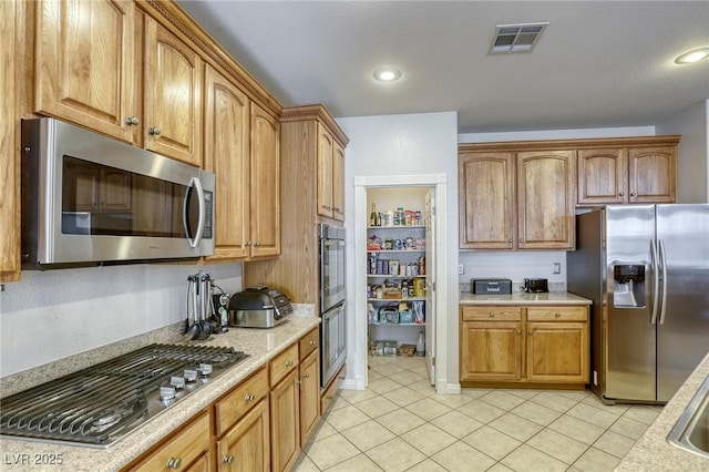 kitchen with appliances with stainless steel finishes and light tile patterned flooring