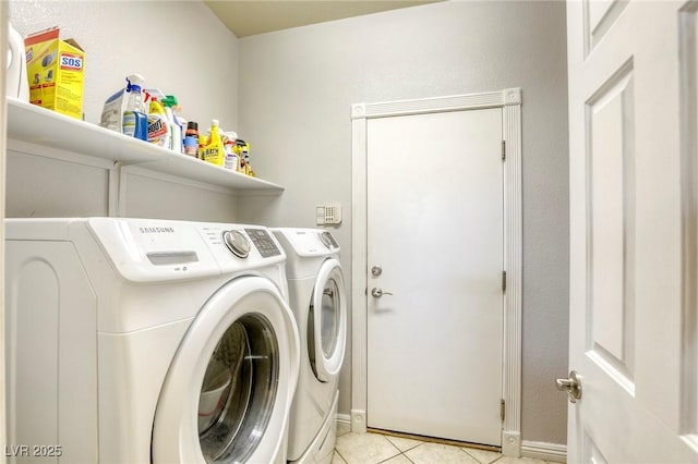 clothes washing area featuring light tile patterned flooring and separate washer and dryer