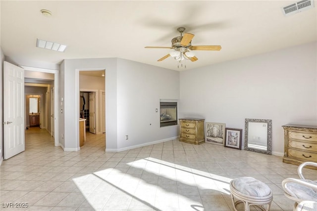 interior space featuring ceiling fan, a multi sided fireplace, and light tile patterned floors