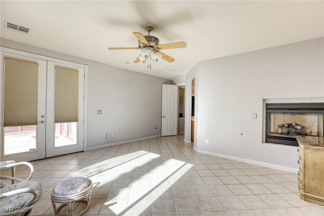 tiled living room with ceiling fan, french doors, and lofted ceiling