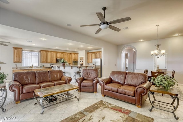 living room with ceiling fan with notable chandelier