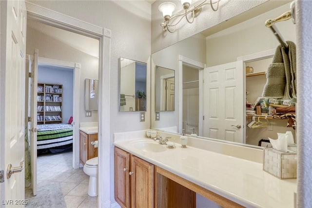 bathroom featuring vanity, toilet, a chandelier, and tile patterned floors