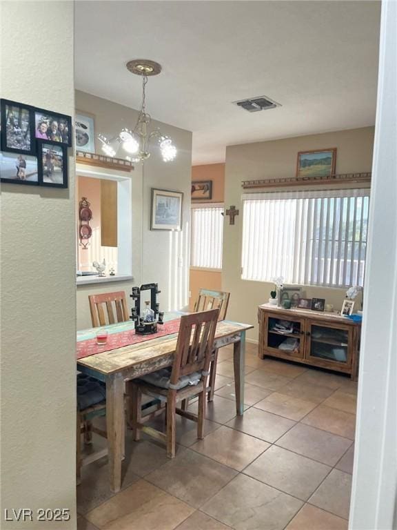 dining area with a notable chandelier and tile patterned floors