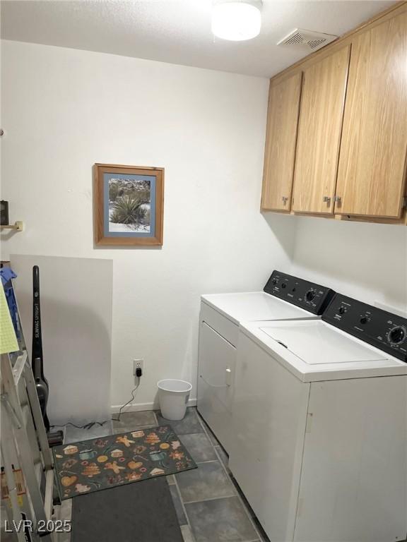 laundry area featuring washer and clothes dryer and cabinets