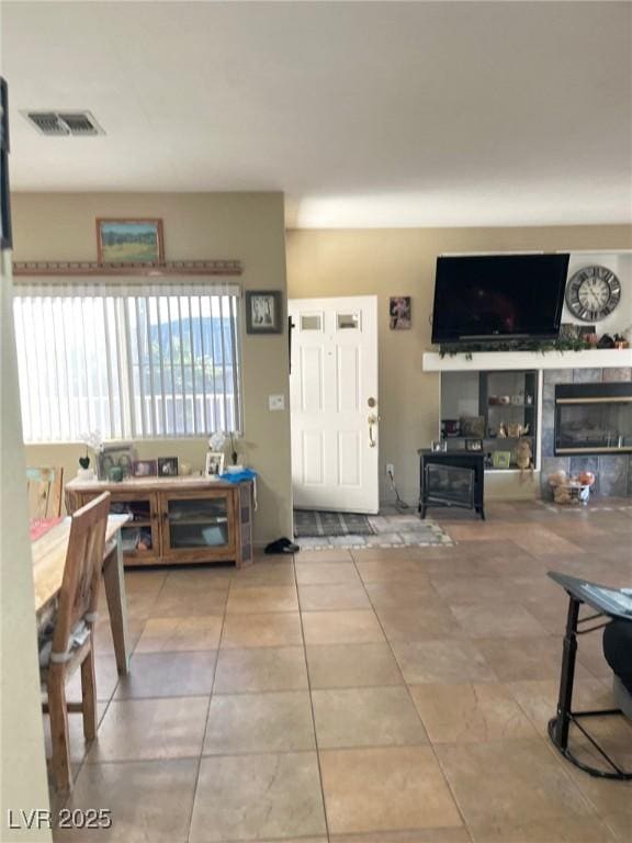 foyer entrance featuring a tile fireplace and light tile patterned floors