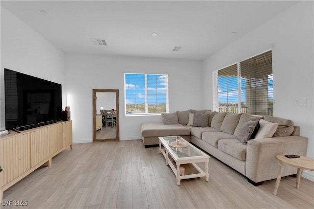 living room with light hardwood / wood-style flooring and a healthy amount of sunlight