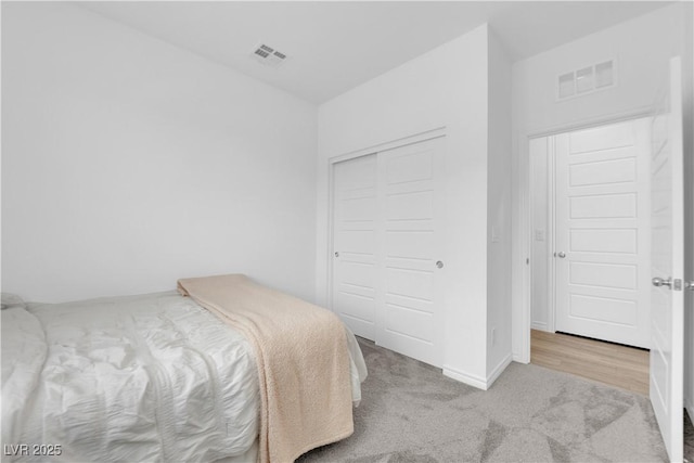 bedroom with light carpet and a closet