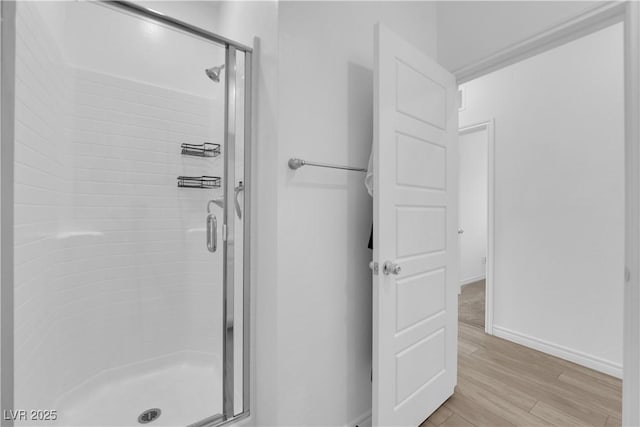 bathroom with hardwood / wood-style floors and an enclosed shower