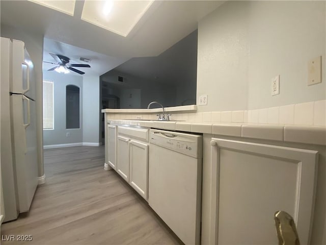 kitchen featuring white appliances, ceiling fan, sink, light hardwood / wood-style floors, and white cabinetry