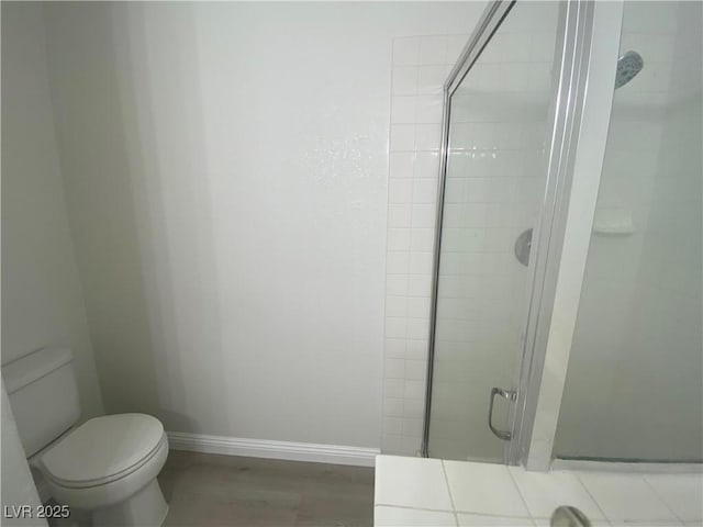 bathroom featuring toilet, wood-type flooring, and walk in shower