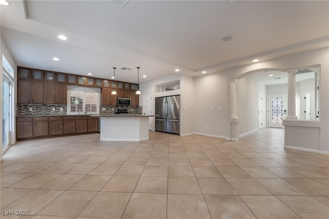 kitchen with a center island, stainless steel appliances, decorative columns, pendant lighting, and light tile patterned floors