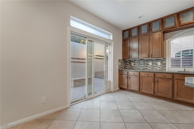 kitchen featuring tasteful backsplash, sink, and light tile patterned floors