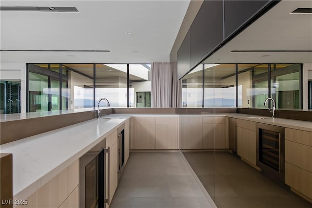 kitchen with light brown cabinetry, sink, and wine cooler