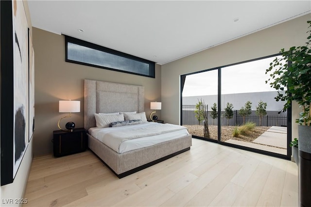 bedroom with light wood-type flooring and access to outside