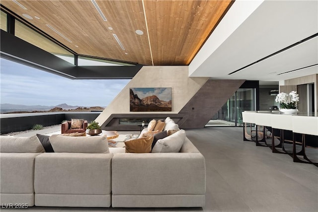 living room featuring floor to ceiling windows, a mountain view, and wood ceiling