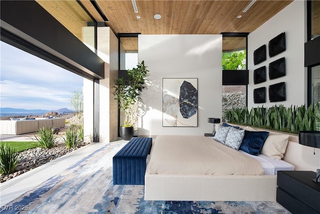 bedroom with multiple windows, a mountain view, and wooden ceiling