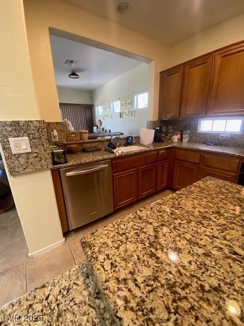 kitchen with dishwasher, sink, decorative backsplash, light tile patterned floors, and kitchen peninsula