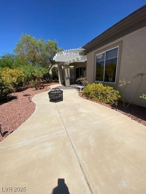 view of patio / terrace with a pergola and an outdoor fire pit