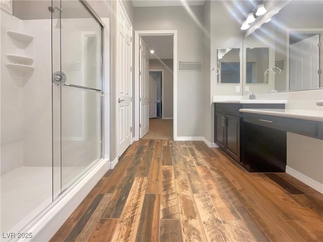 bathroom featuring hardwood / wood-style floors, vanity, and walk in shower