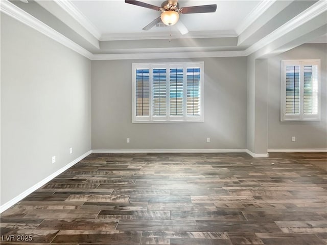 spare room with a tray ceiling, ceiling fan, dark wood-type flooring, and ornamental molding