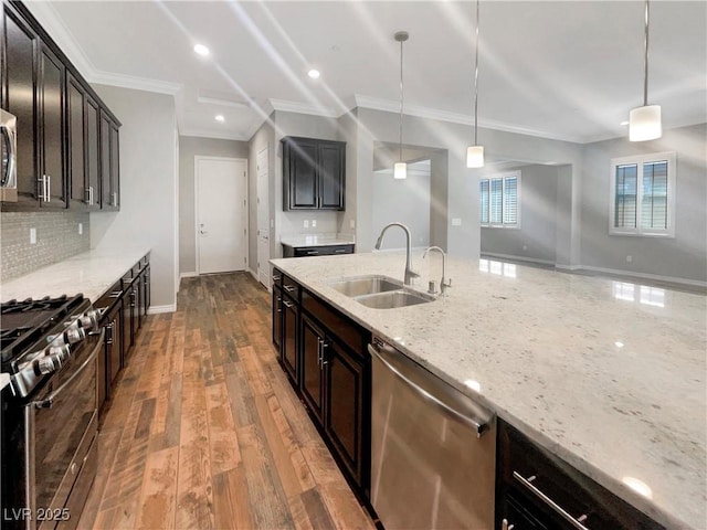 kitchen featuring decorative light fixtures, light stone counters, sink, and appliances with stainless steel finishes