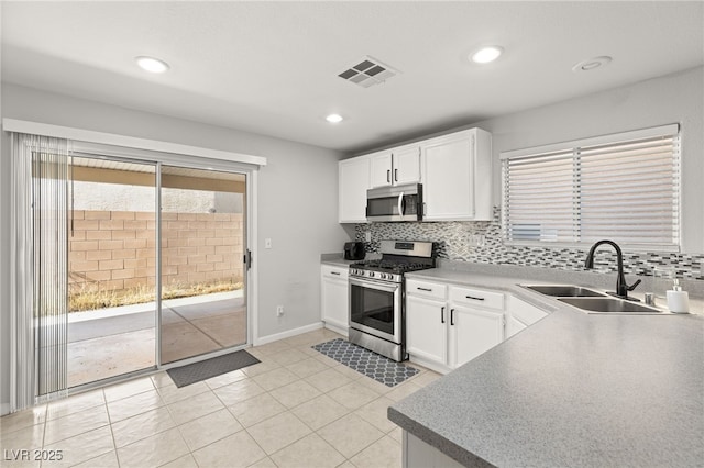 kitchen featuring white cabinets, sink, appliances with stainless steel finishes, and tasteful backsplash