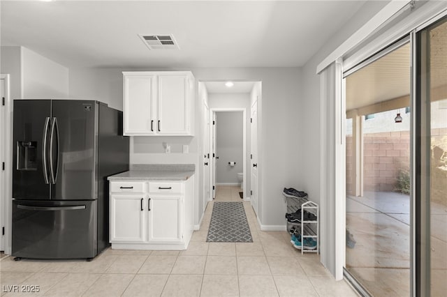 kitchen featuring white cabinetry, stainless steel fridge with ice dispenser, and light tile patterned flooring