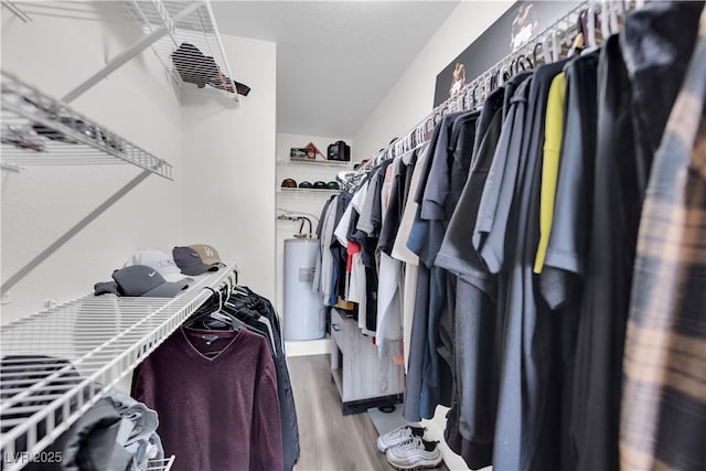 spacious closet with hardwood / wood-style floors and water heater