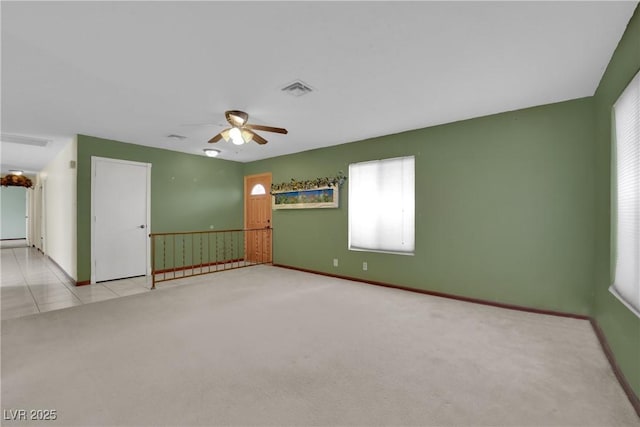 carpeted spare room featuring ceiling fan