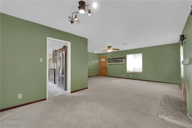 spare room with ceiling fan and light carpet