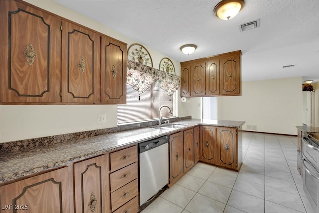 kitchen featuring kitchen peninsula, stainless steel dishwasher, sink, light tile patterned floors, and dark stone countertops