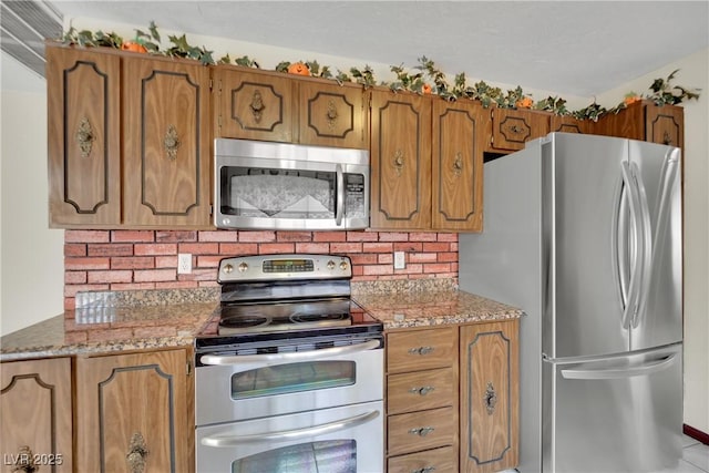 kitchen with decorative backsplash, stainless steel appliances, and light stone counters