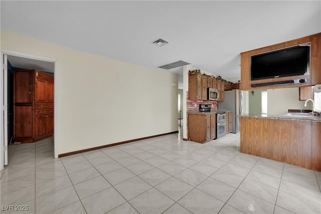 kitchen with light tile patterned flooring, backsplash, stainless steel appliances, and sink