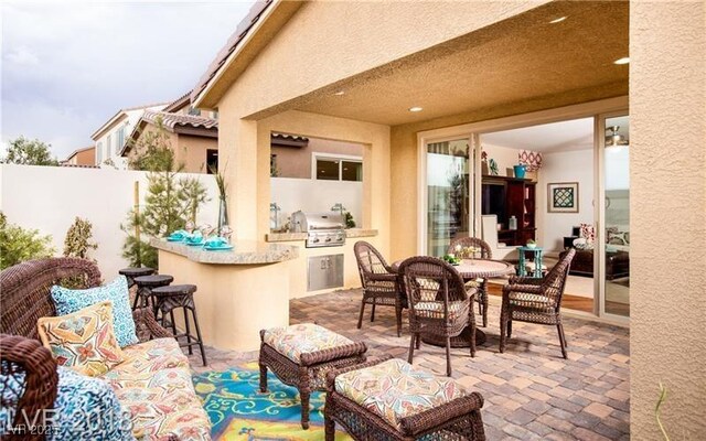 view of patio / terrace with an outdoor kitchen, a grill, and a bar