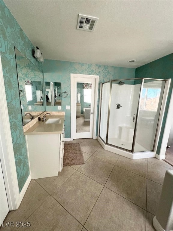 bathroom featuring tile patterned flooring, vanity, an enclosed shower, and a textured ceiling