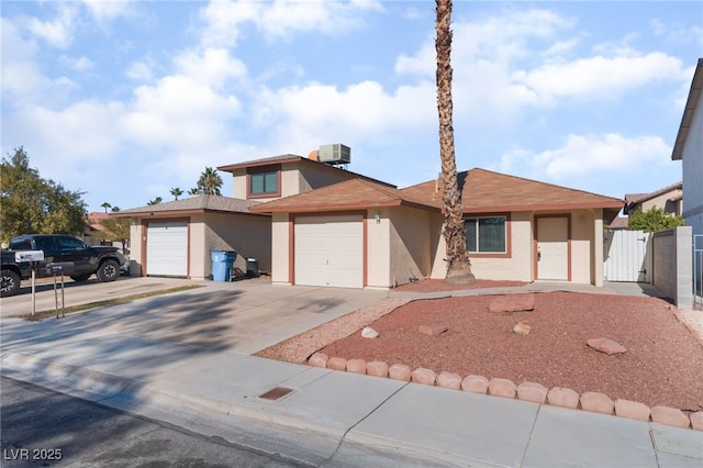 view of front of property featuring a garage and cooling unit