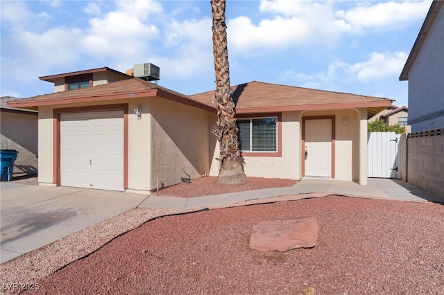 view of front of home with central AC and a garage