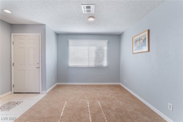 carpeted empty room featuring a textured ceiling