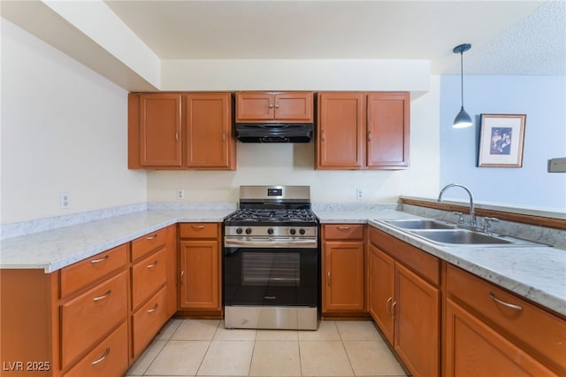 kitchen with sink, hanging light fixtures, gas range, light stone counters, and light tile patterned floors