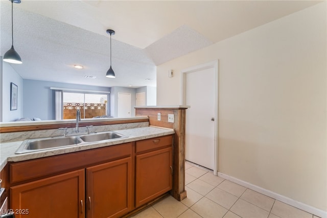 kitchen with a textured ceiling, light tile patterned flooring, hanging light fixtures, and sink